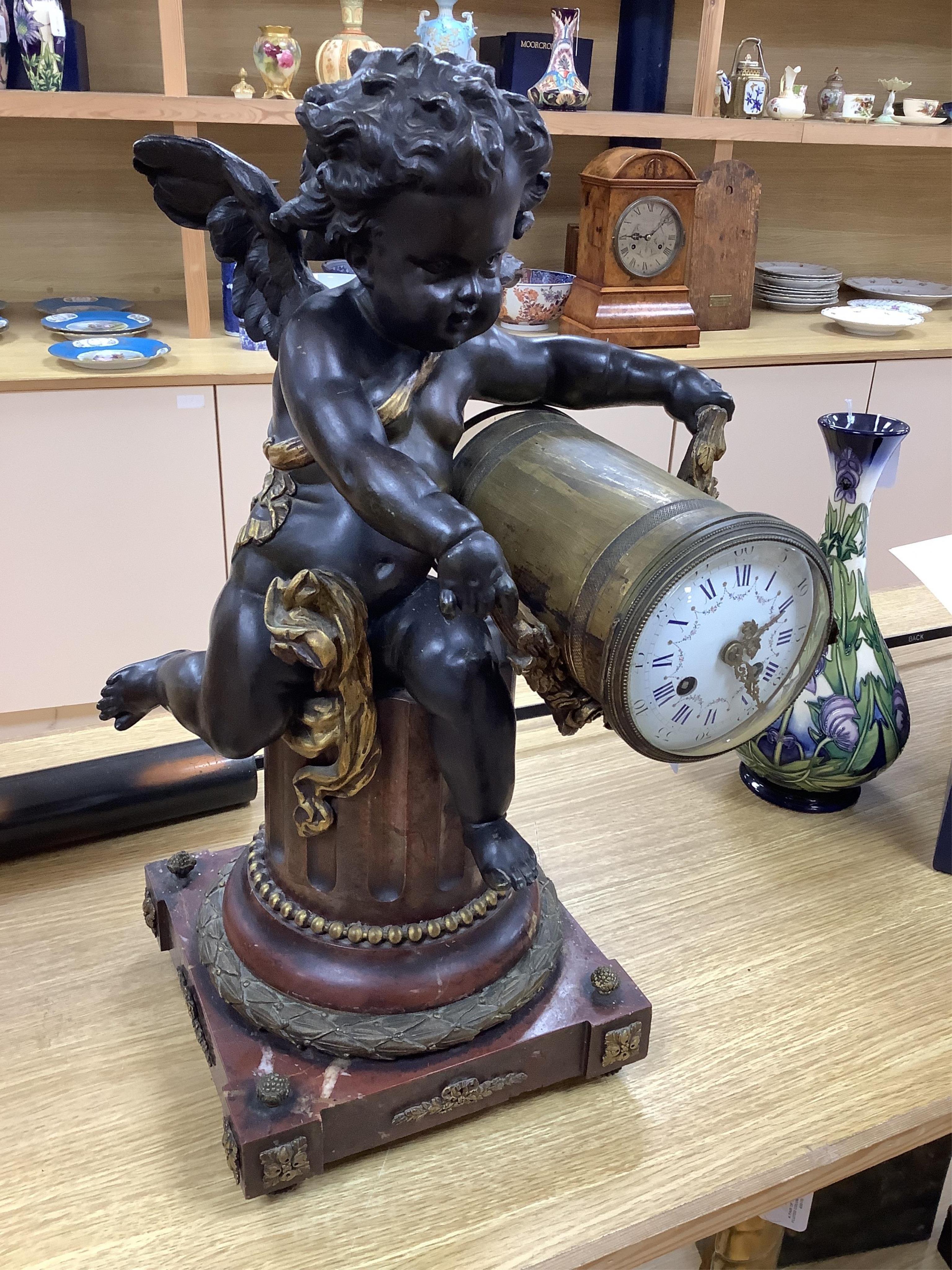 A large Louis XVI style bronze and rouge marble cherub clock, late 19th century, 56cm high